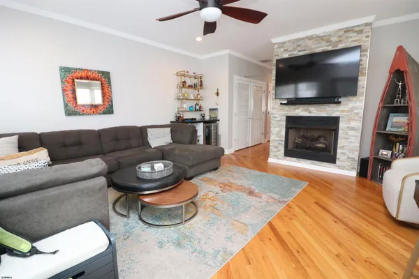 a living room with furniture a flat screen tv and a fireplace