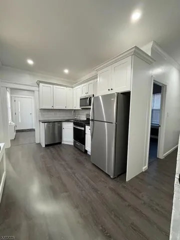 a kitchen with stainless steel appliances a refrigerator and a stove top oven