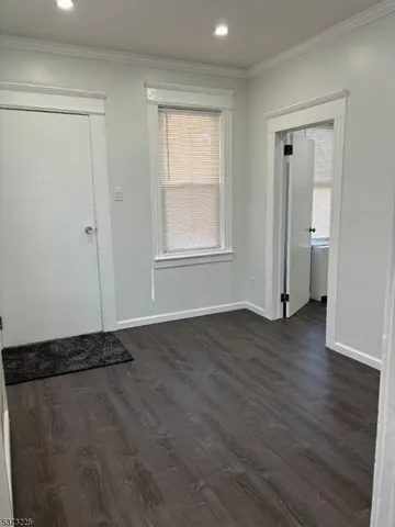 an empty room with wooden floor and window
