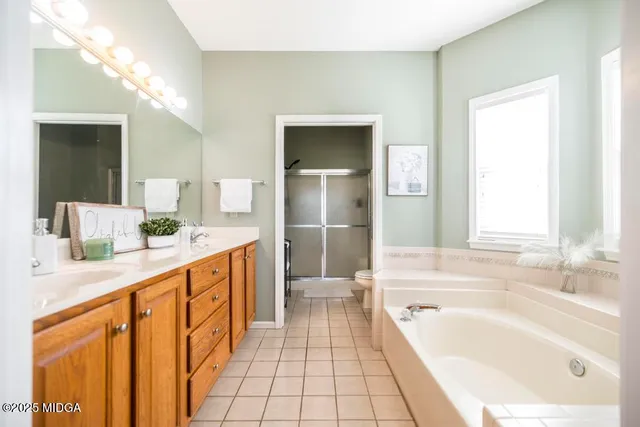 a spacious bathroom with a tub sink and mirror