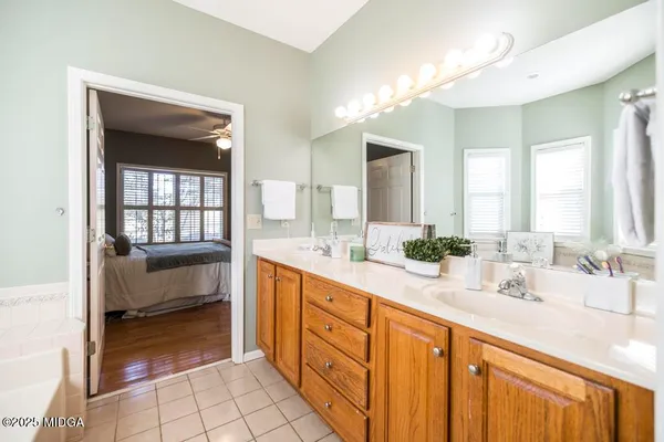 a spacious bathroom with a double vanity sink a mirror and a bathtub