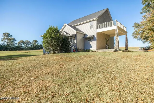a view of a house with a yard and a large tree
