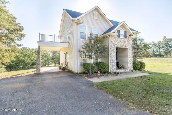 a view of a house with a yard and large tree