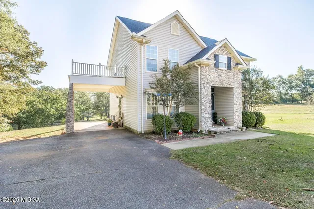 a view of a house with a yard and large tree
