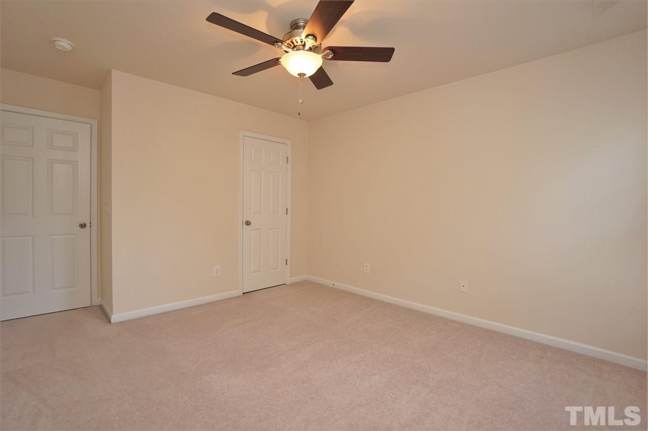 7718 Tanby Court Raleigh, NC 27613 - Photo 12 of 20 an empty room with a ceiling fan and a window