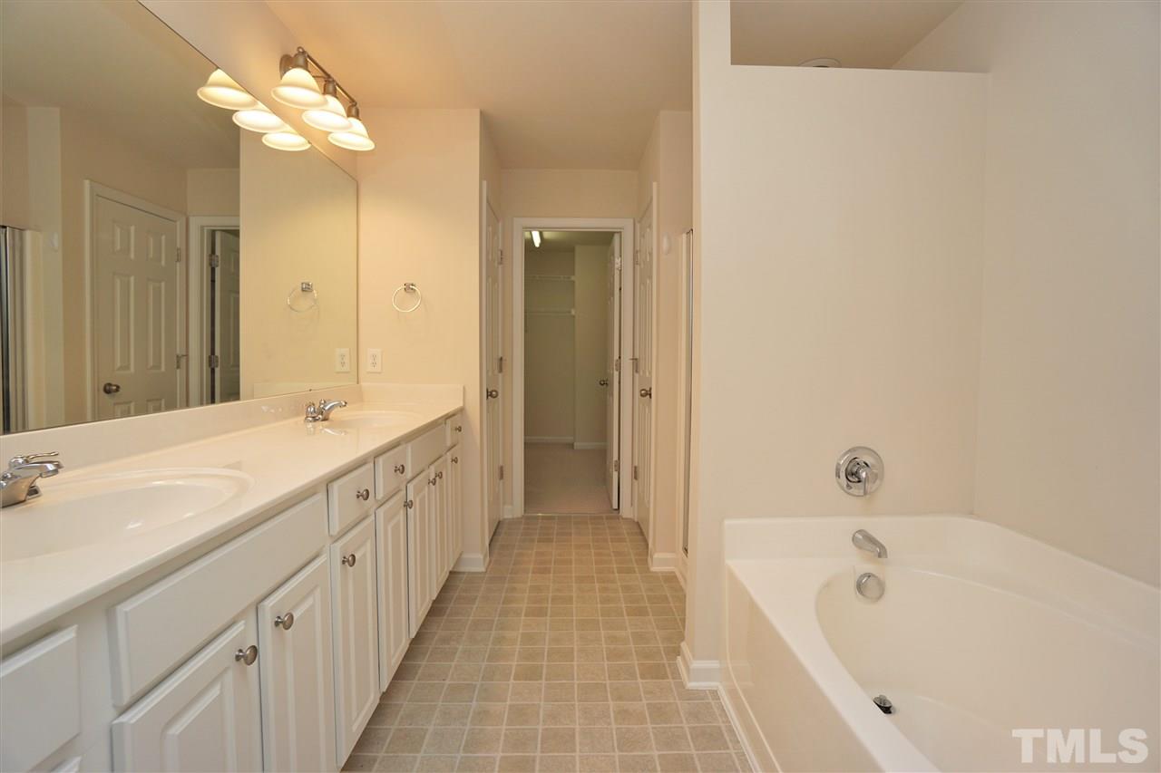 7718 Tanby Court Raleigh, NC 27613 - Photo 14 of 20 a spacious bathroom with a tub sink and mirror
