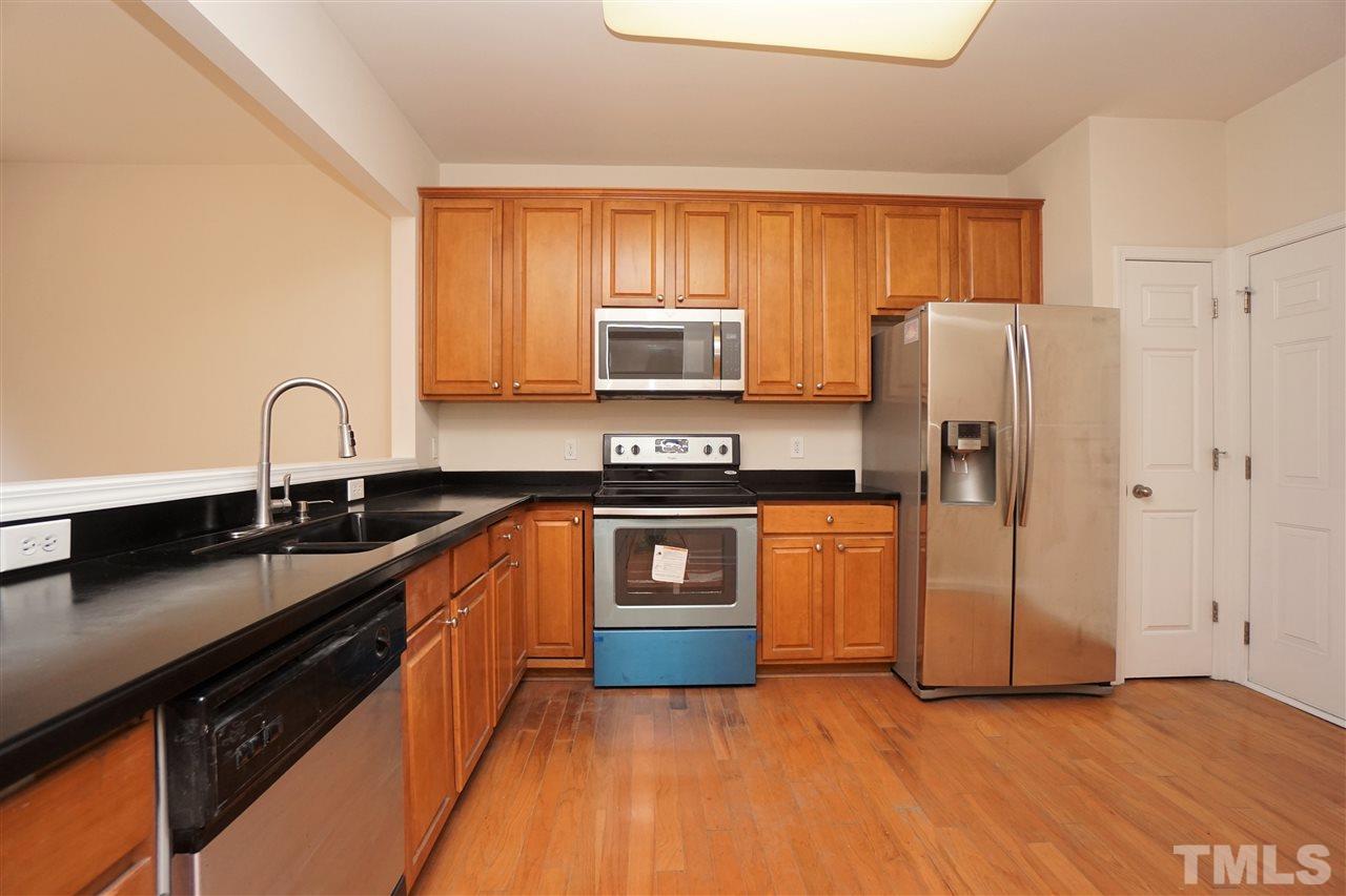 7718 Tanby Court Raleigh, NC 27613 - Photo 7 of 20 a kitchen with stainless steel appliances granite countertop a stove a sink and a refrigerator