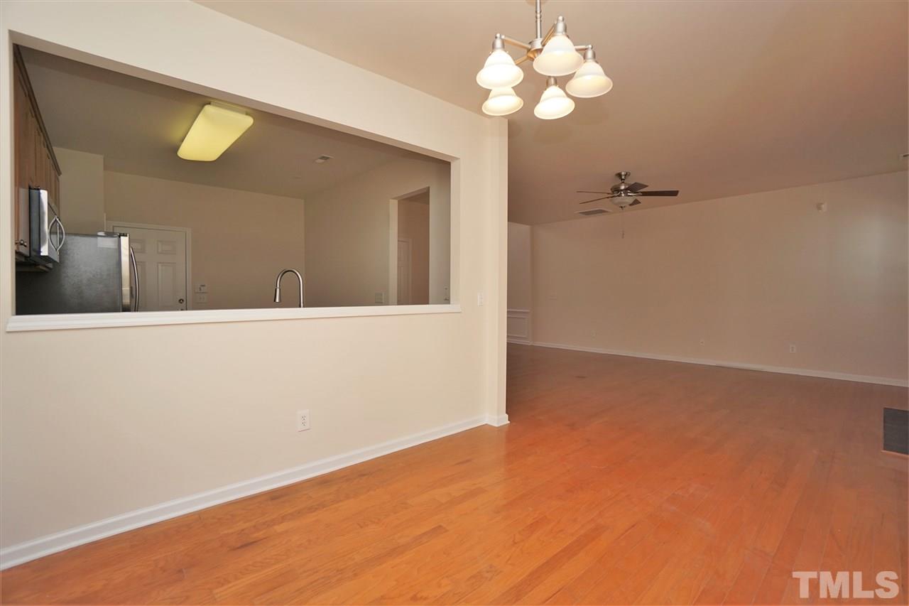 7718 Tanby Court Raleigh, NC 27613 - Photo 8 of 20 a view of a room with a chandelier fan and wooden floor
