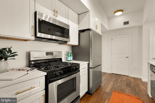 a kitchen with kitchen island a sink stainless steel appliances and cabinets