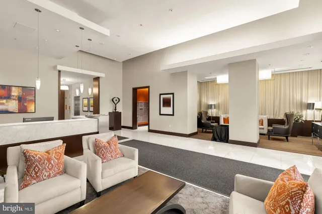 a large white kitchen with stainless steel appliances granite countertop a stove a sink a dining table and chairs