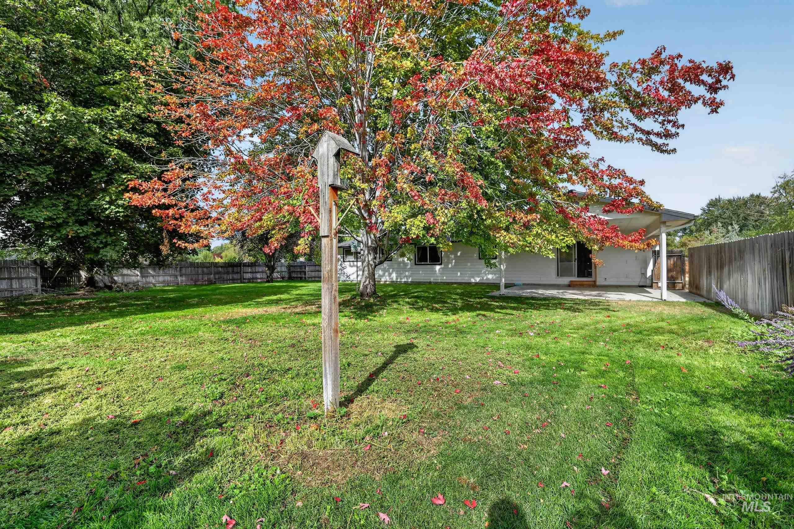9055 West Highlander Road Boise, ID 83709 - Photo 30 of 39 Expansive lawn with mature trees and a privacy fence