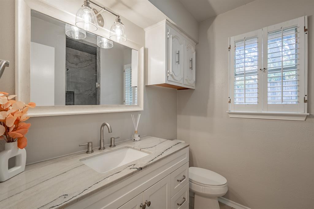 3316 Appalachian Way Plano, TX 75075 - Photo 22 of 29 a bathroom with a granite countertop sink a toilet and a mirror