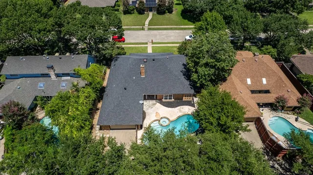 an aerial view of a house with a yard and a large tree