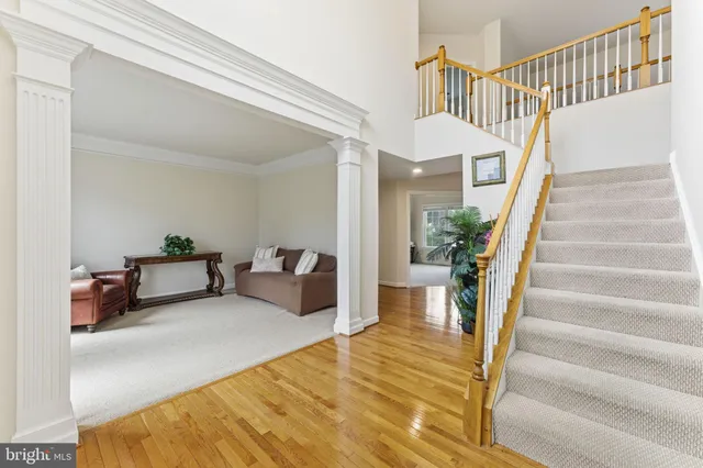 a view of a livingroom with furniture stairs wooden floor and a potted plant