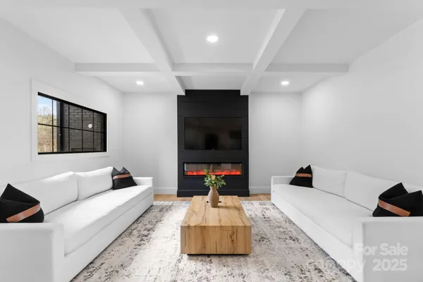 a living room with furniture and view of kitchen