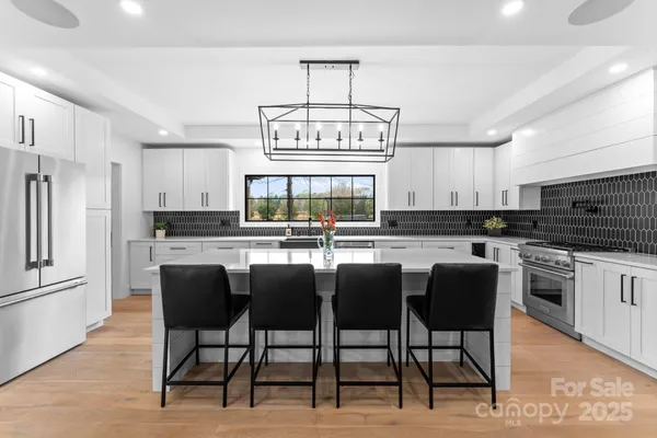 a kitchen with a sink a counter top space cabinets and stainless steel appliances