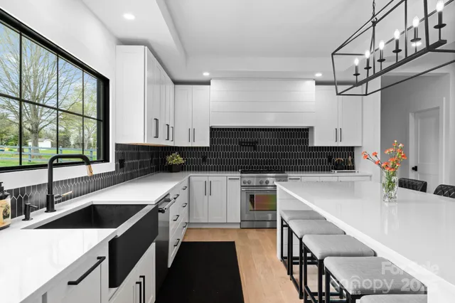 a large kitchen with kitchen island a sink table and chairs