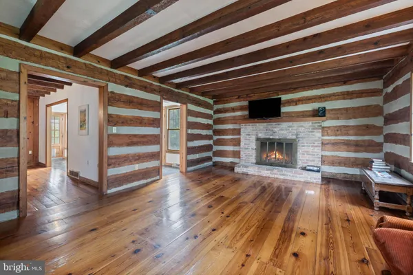 a view of a room with a large window and wooden floor
