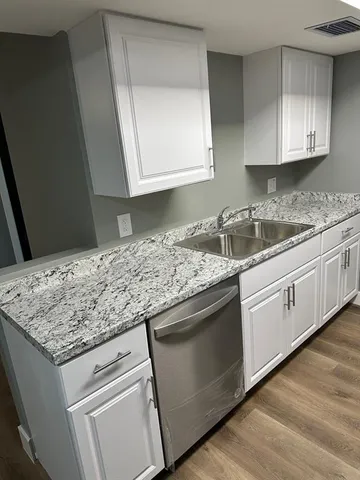 a kitchen with granite countertop cabinets stainless steel appliances and sink