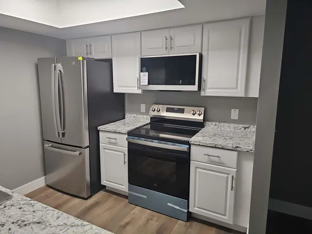 a kitchen with granite countertop cabinets stainless steel appliances and a counter space