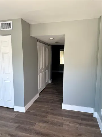 a view of a hallway with wooden floor