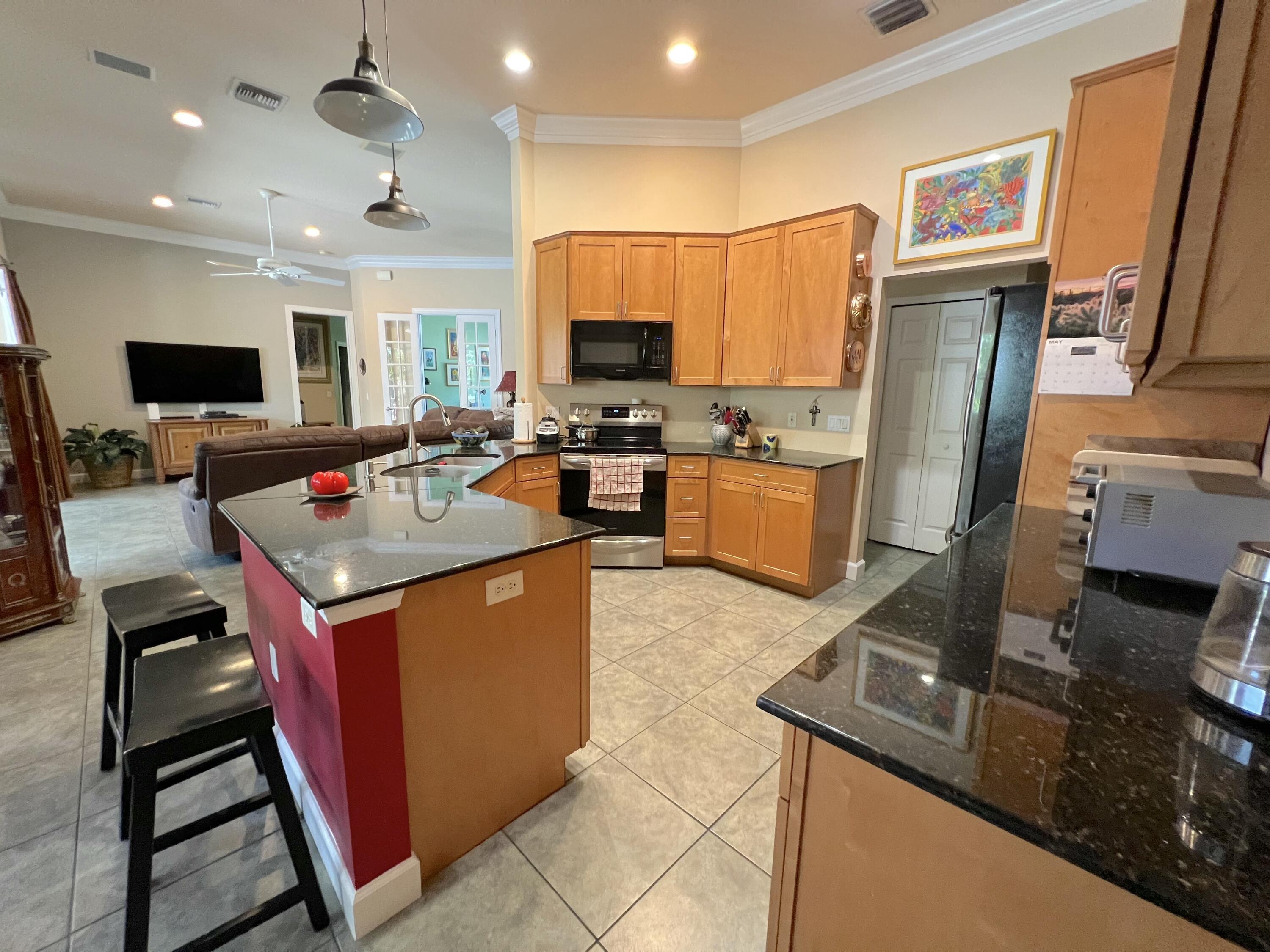 4292 Southeast Rainbows End Stuart, FL 34997 - Photo 21 of 53 a open kitchen with stainless steel appliances granite countertop a stove top oven a sink dishwasher and cabinets with wooden floor
