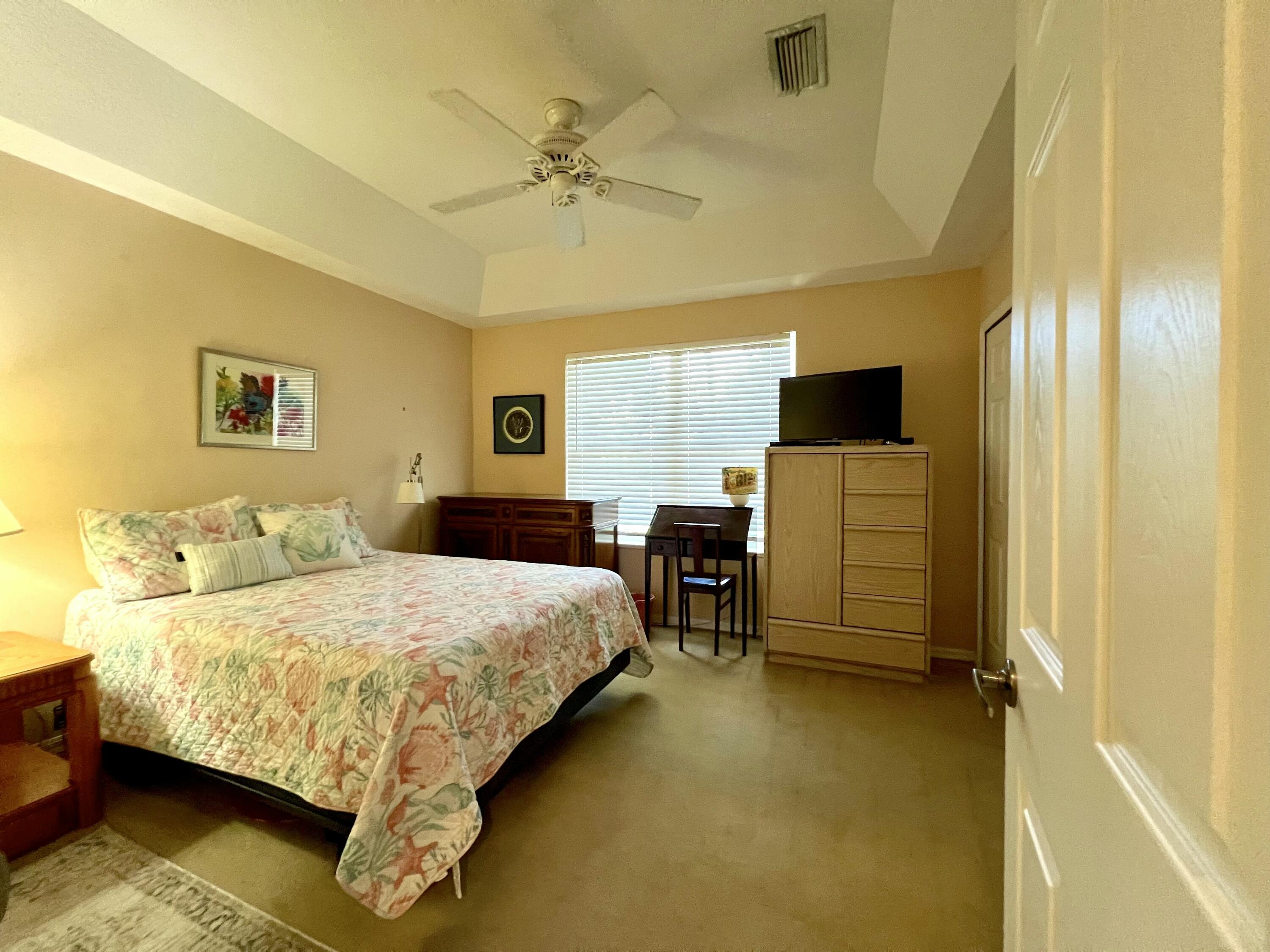 4292 Southeast Rainbows End Stuart, FL 34997 - Photo 27 of 53 a bedroom with a bed and a table in it