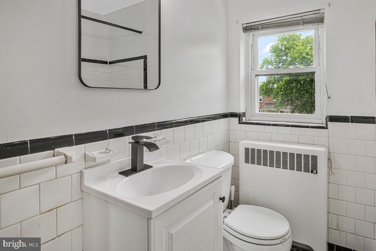 3040 Federal Street Baltimore, MD 21213 - Photo 20 of 41 a bathroom with a sink a toilet and window
