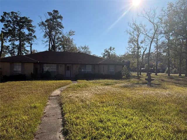 an empty room with wooden floor fireplace and windows