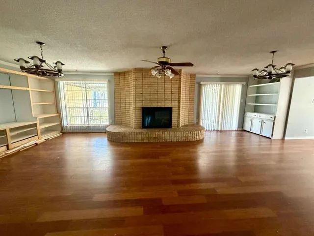 a view of a livingroom with wooden floor and a fireplace