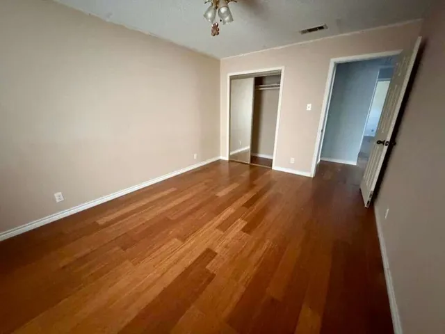 wooden floor in an empty room with a window
