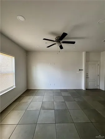 a view of a livingroom with a flesh screen tv and window