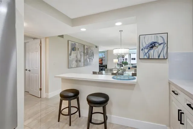 a kitchen with stainless steel appliances a dining table and chairs