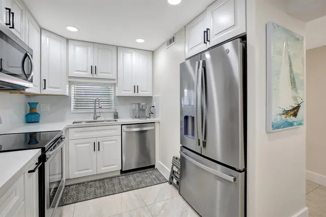 a kitchen with stainless steel appliances a refrigerator sink and microwave