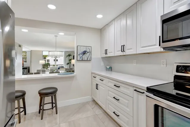 a kitchen with granite countertop white cabinets and appliances