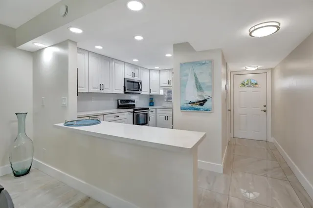 a large kitchen with a large counter top appliances and cabinets