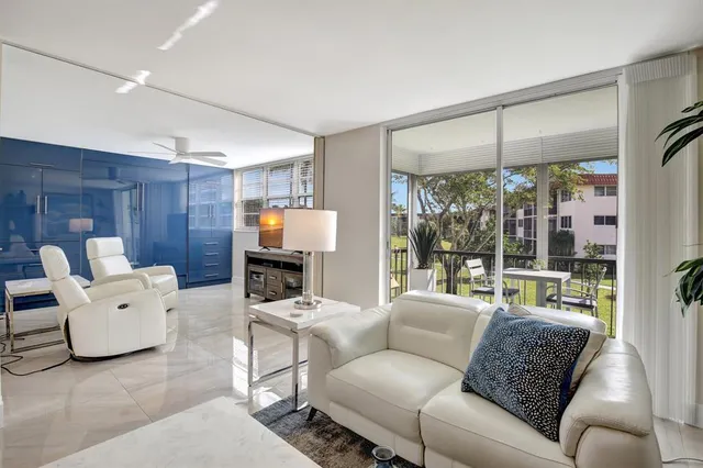 a living room with furniture a large window and a fireplace