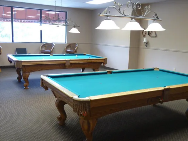 a room with pool table and windows