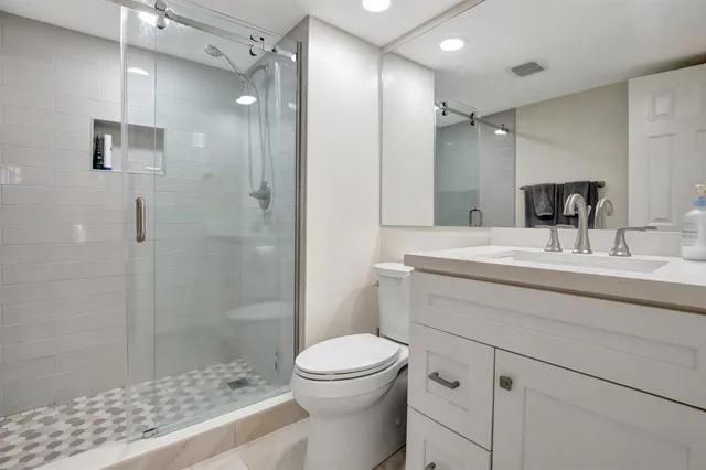 a bathroom with a sink a toilet and shower