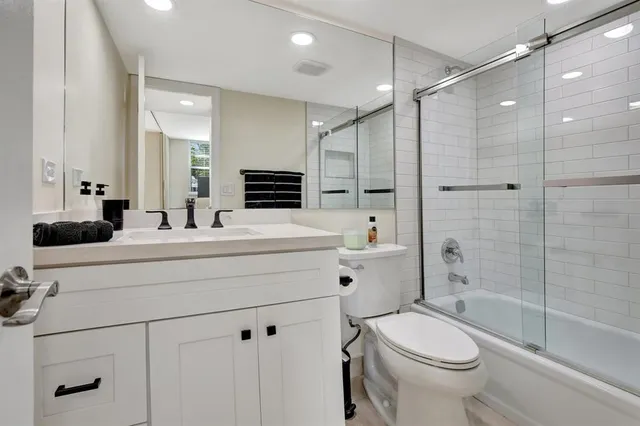 a bathroom with a double vanity sink toilet mirror and shower
