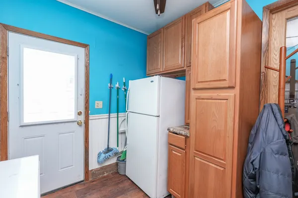 a white refrigerator freezer and a wooden floor