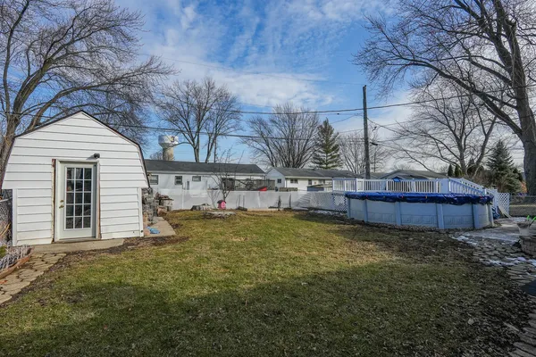 a view of backyard with wooden fence and large trees