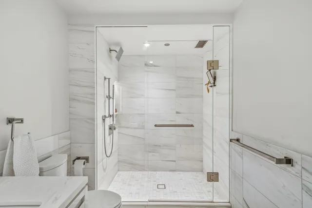 a bathroom with a sink a toilet and shower