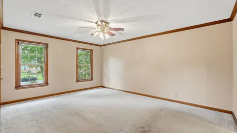 an empty room with chandelier fan