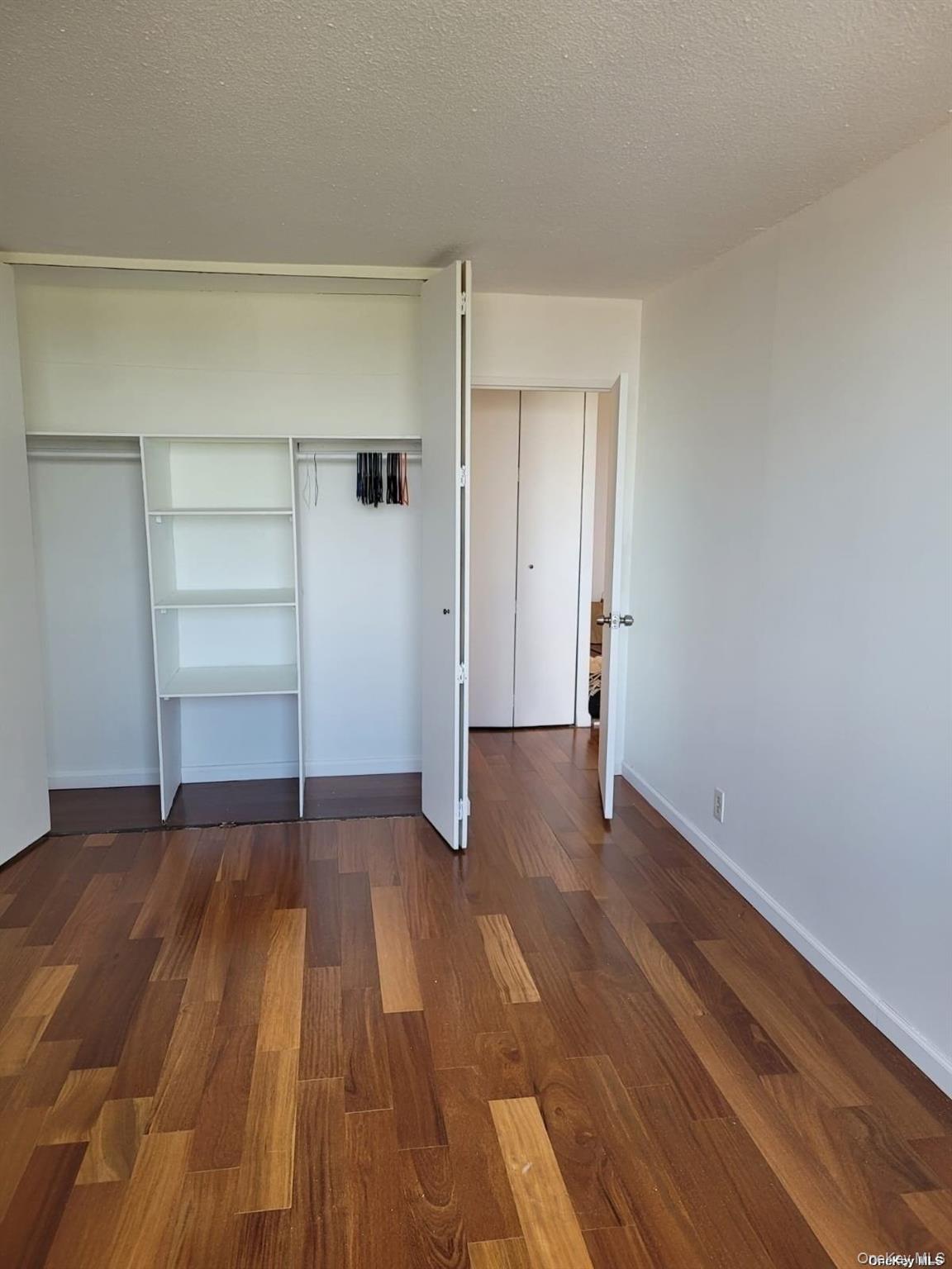 118-17 Union Turnpike, Unit 14E Queens, NY 11375 - Photo 13 of 24 a view of an empty room with wooden floor and closet
