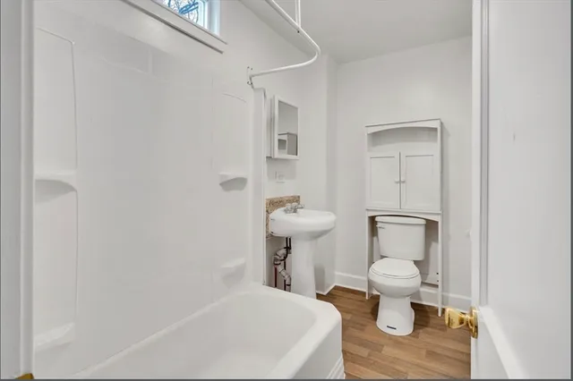 a white toilet sitting next to a bathroom sink and a mirror