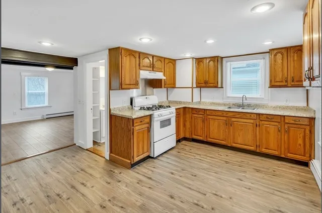 a kitchen with stainless steel appliances granite countertop a sink stove and wooden cabinets