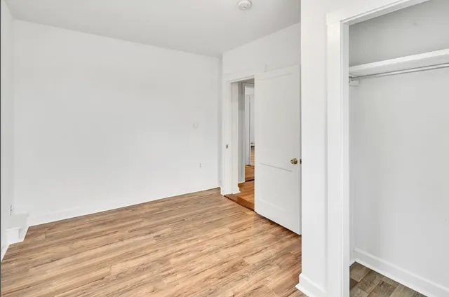 a view of a room with wooden floor and a bathroom