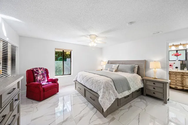 a spacious bedroom with a bed a couch and a chandelier