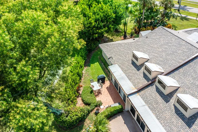 an aerial view of residential houses with outdoor space and trees all around